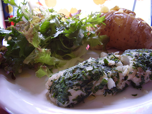 Filé de peixe escalfado com salada verde e batata.